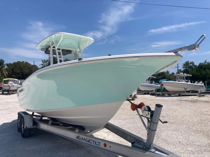 Slide: The Image of 2025 Key West 244CC boat on trailer, light blue hull, clear sky background. - 1