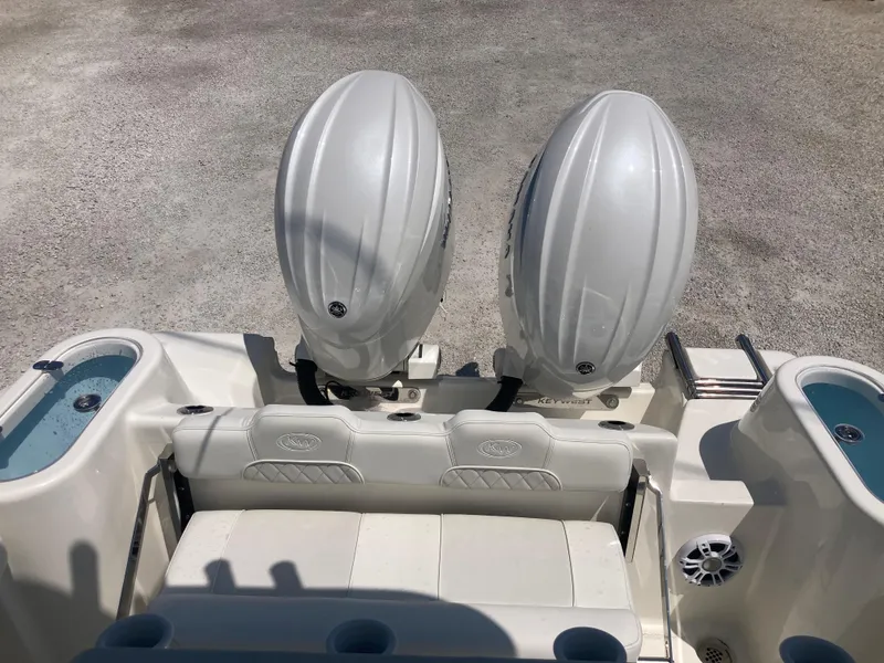 Slide: The Image of 2025 Key West 244CC boat with dual outboard engines, rear seating, and cup holders. - 17