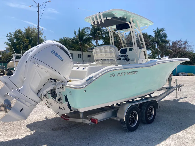 Slide: The Image of 2025 Key West 244CC boat on trailer with Yamaha engine, parked outdoors. - 2
