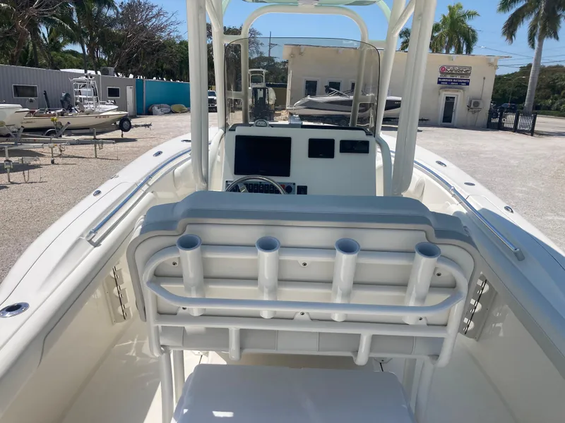Slide: The Image of 2025 Key West 244CC boat interior with rod holders and console, parked outdoors. - 5