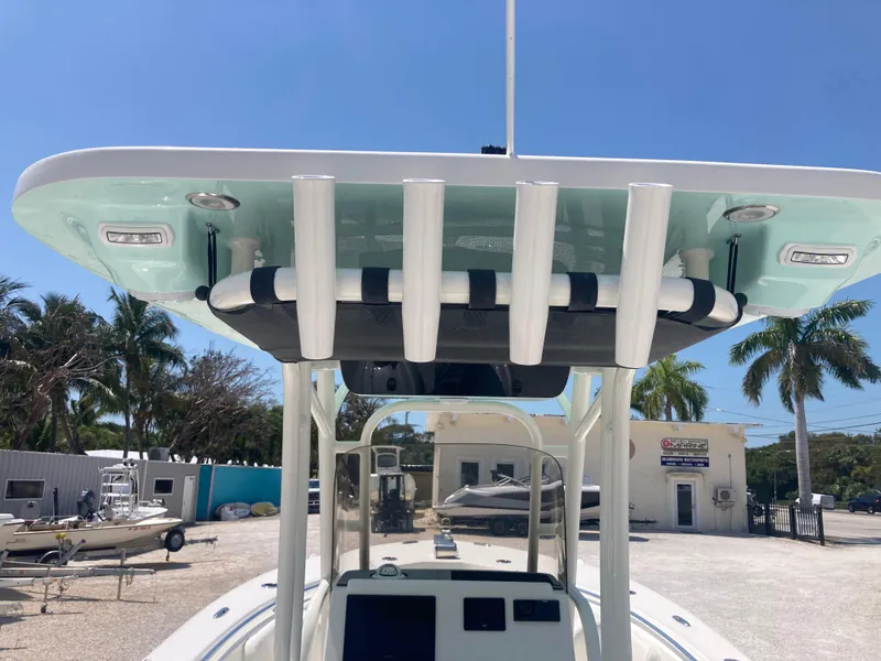 Slide: The Image of 2025 Key West 244CC boat with T-top and rod holders, parked outdoors. - 6