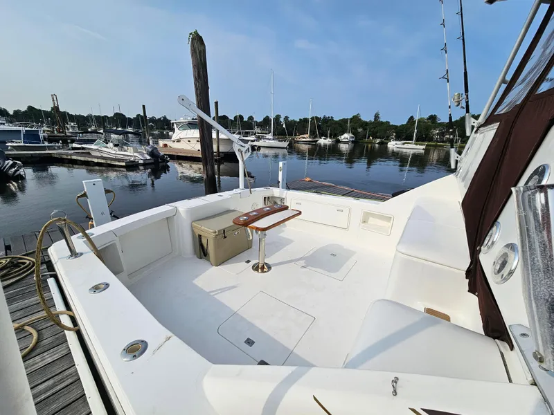 Slide: The Image of 1998 Ocean Yachts 40 docked at a marina, featuring spacious deck and seating area. - 13