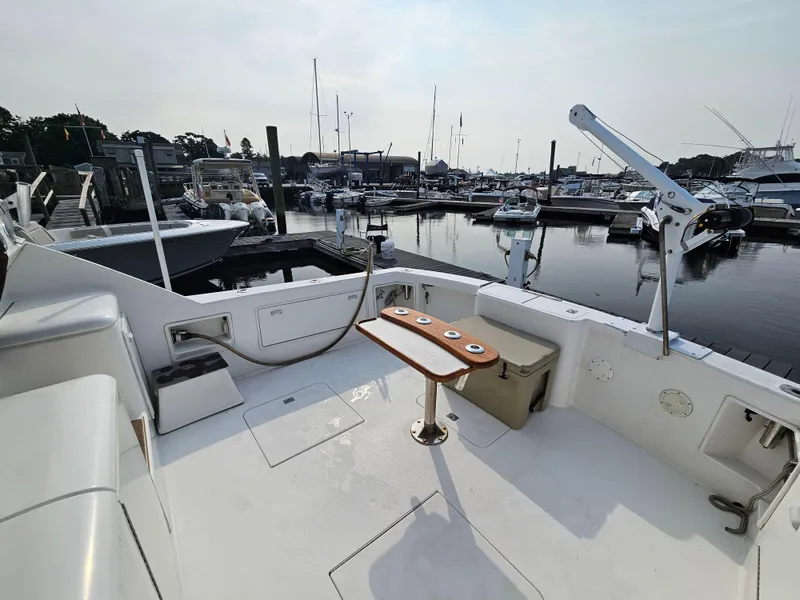 Slide: The Image of 1998 Ocean Yachts 40 docked at marina, featuring spacious deck and fishing equipment. - 14