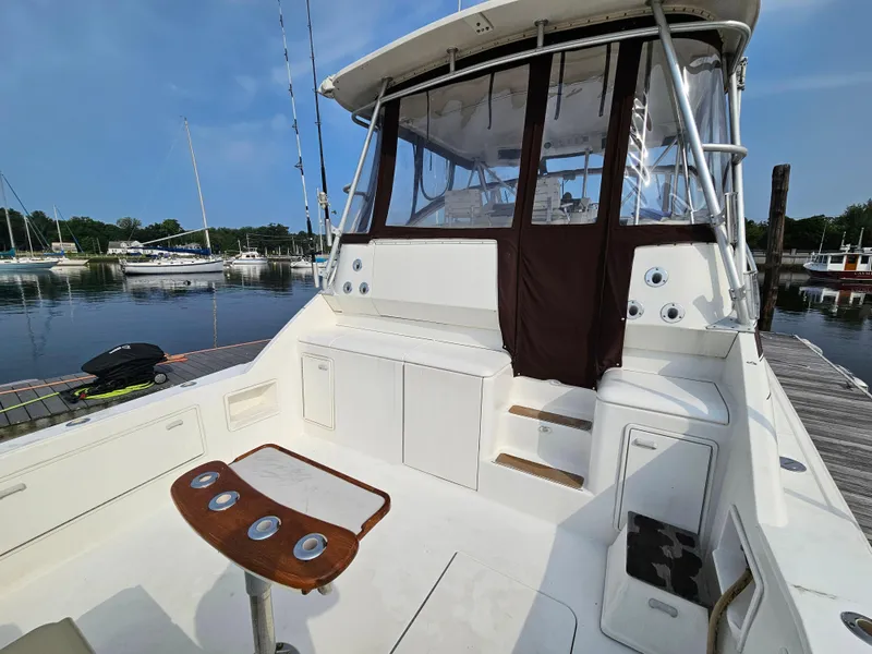 Slide: The Image of 1998 Ocean Yachts 40 boat with spacious deck and fishing rod holders at marina. - 15