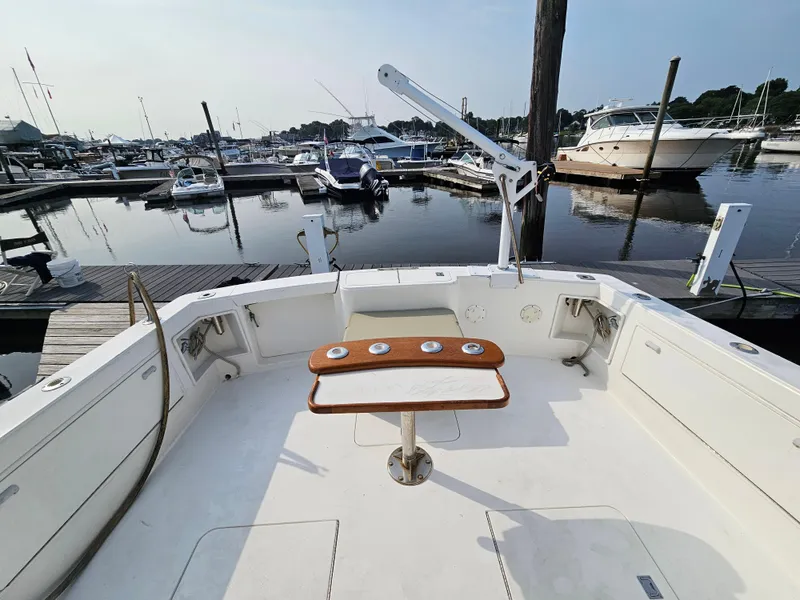Slide: The Image of 1998 Ocean Yachts 40 at marina, featuring spacious deck and fishing rod holders. - 17