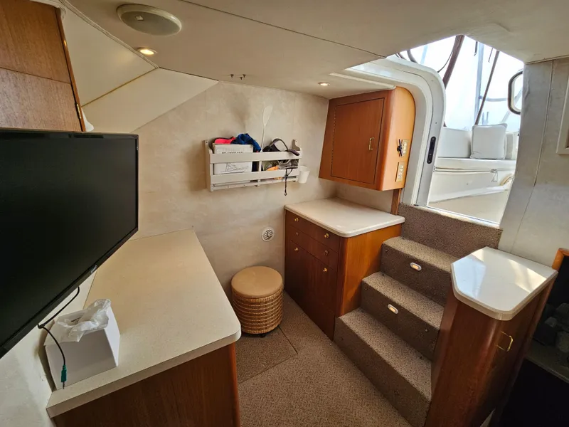 Slide: The Image of Interior of 1998 Ocean Yachts 40, featuring stairs, cabinets, and a TV. - 23