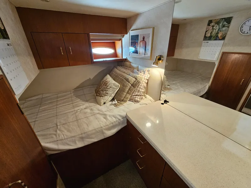 Slide: The Image of Cozy cabin interior of 1998 Ocean Yachts 40, featuring a bed, pillows, and wooden cabinetry. - 30