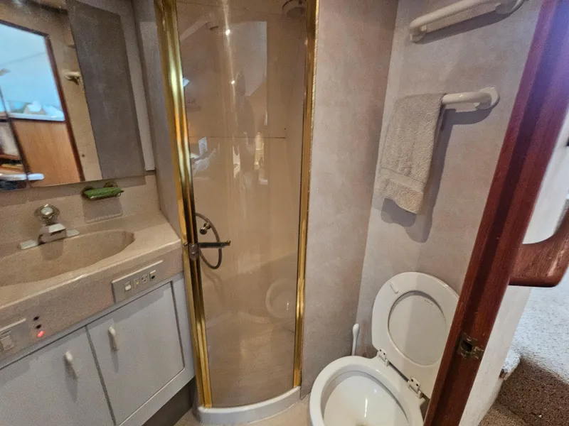 Slide: The Image of Bathroom interior of a 1998 Ocean Yachts 40, featuring shower, sink, and toilet. - 33