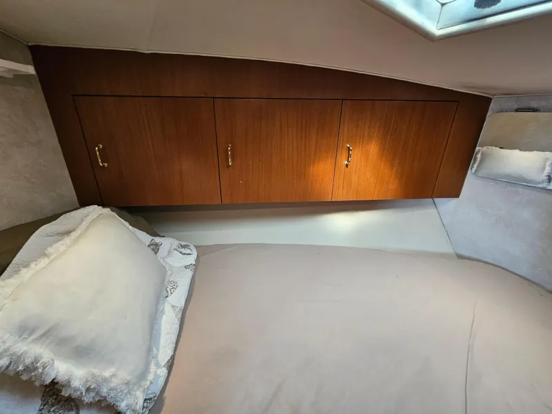 Slide: The Image of 1998 Ocean Yachts 40 interior cabin with wooden cabinets and a cozy bed. - 36
