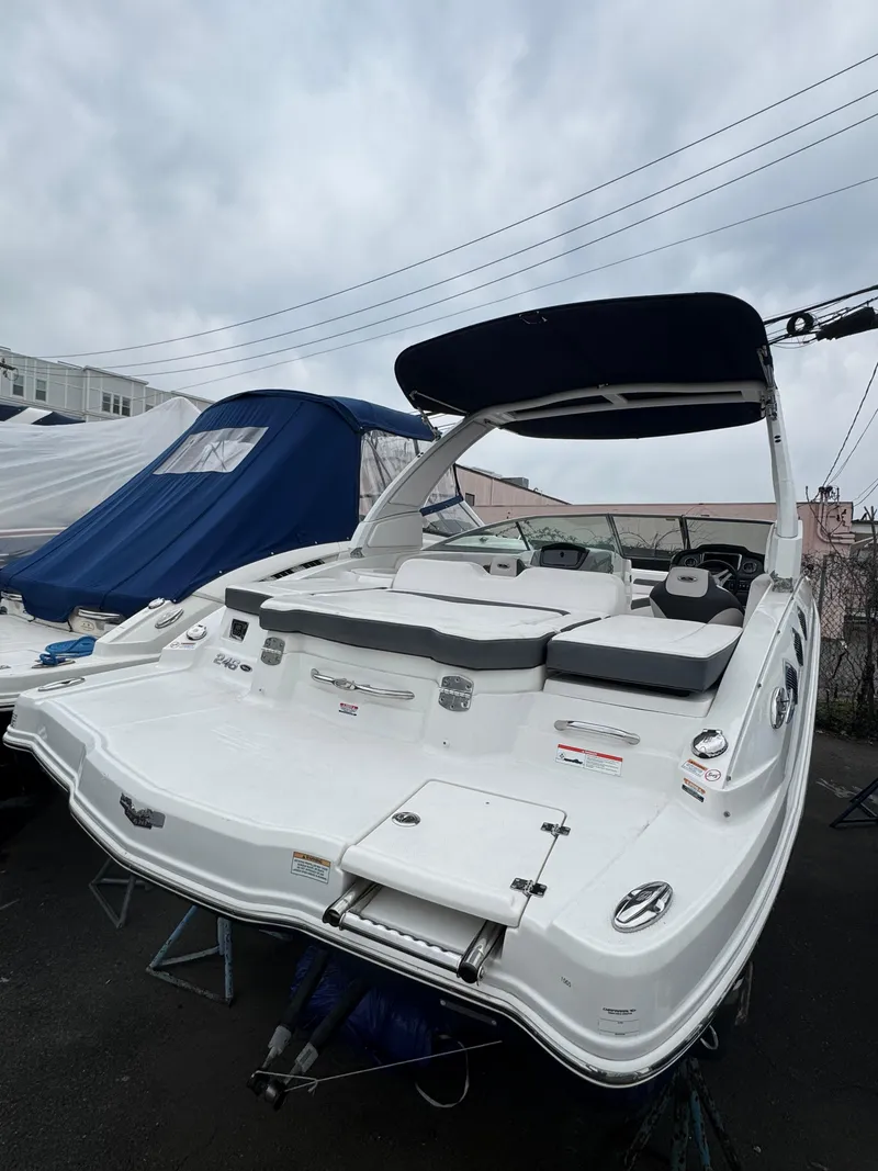 The Image of 2019 Chaparral 246 SSi boat with sleek design, docked outdoors under cloudy skies. - 0
