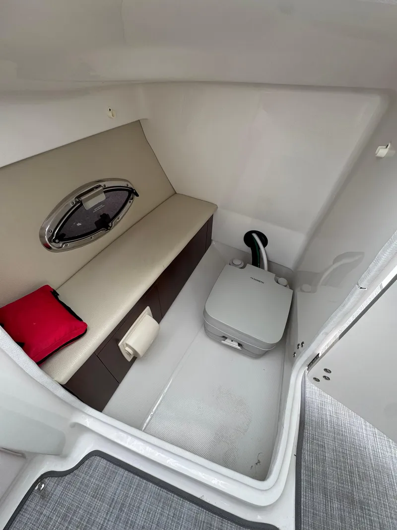 Slide: The Image of 2019 Chaparral 246 SSi boat interior with seating and portable toilet. - 12