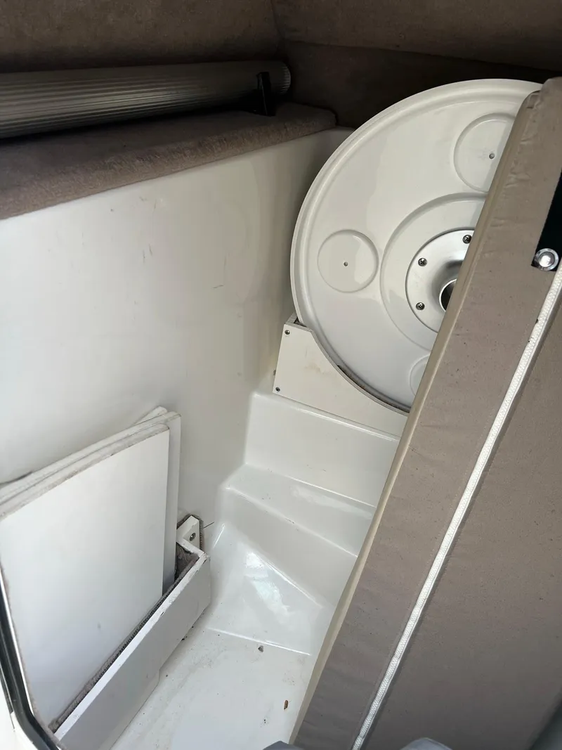 Slide: The Image of Interior storage area of 2011 Sea Ray 270 SLX boat, featuring a circular hatch. - 13