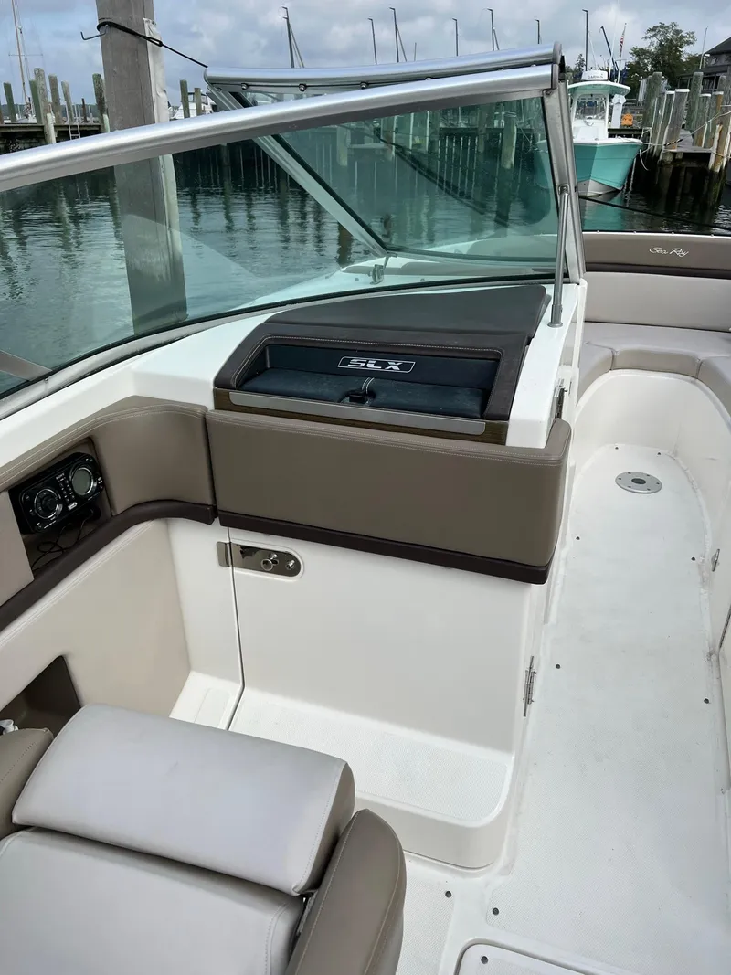 Slide: The Image of 2011 Sea Ray 270 SLX boat interior with beige seating and control panel. - 2
