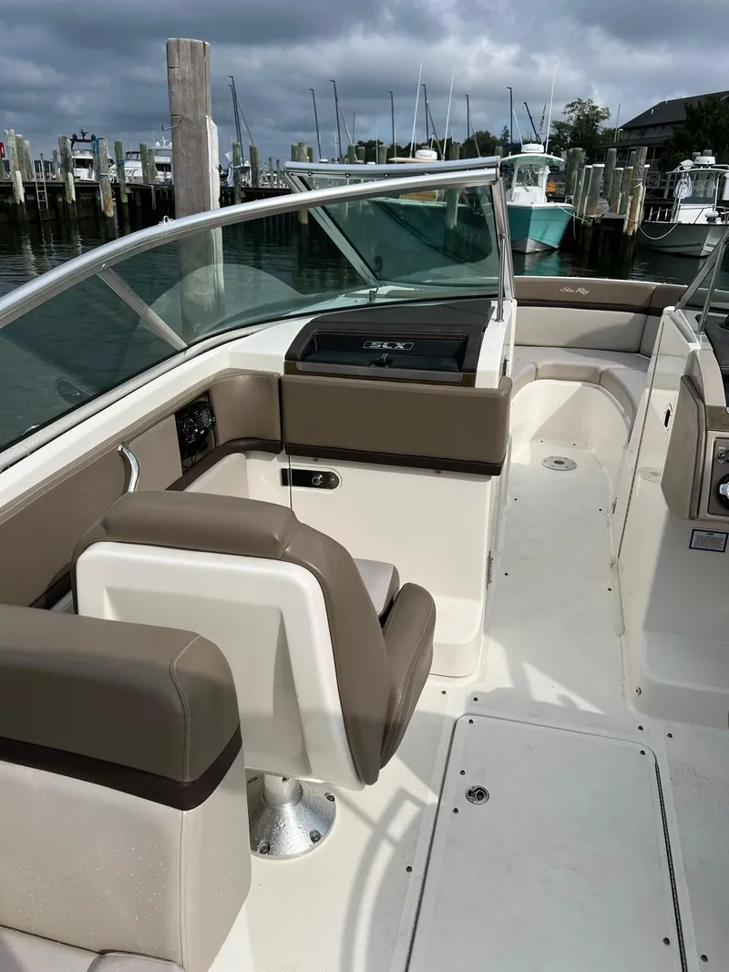 Slide: The Image of 2011 Sea Ray 270 SLX boat interior with seating and dashboard, docked at marina. - 27