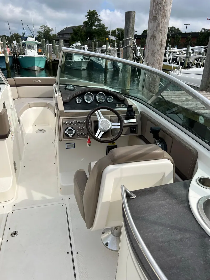 Slide: The Image of 2011 Sea Ray 270 SLX boat interior with steering wheel and dashboard at marina. - 28