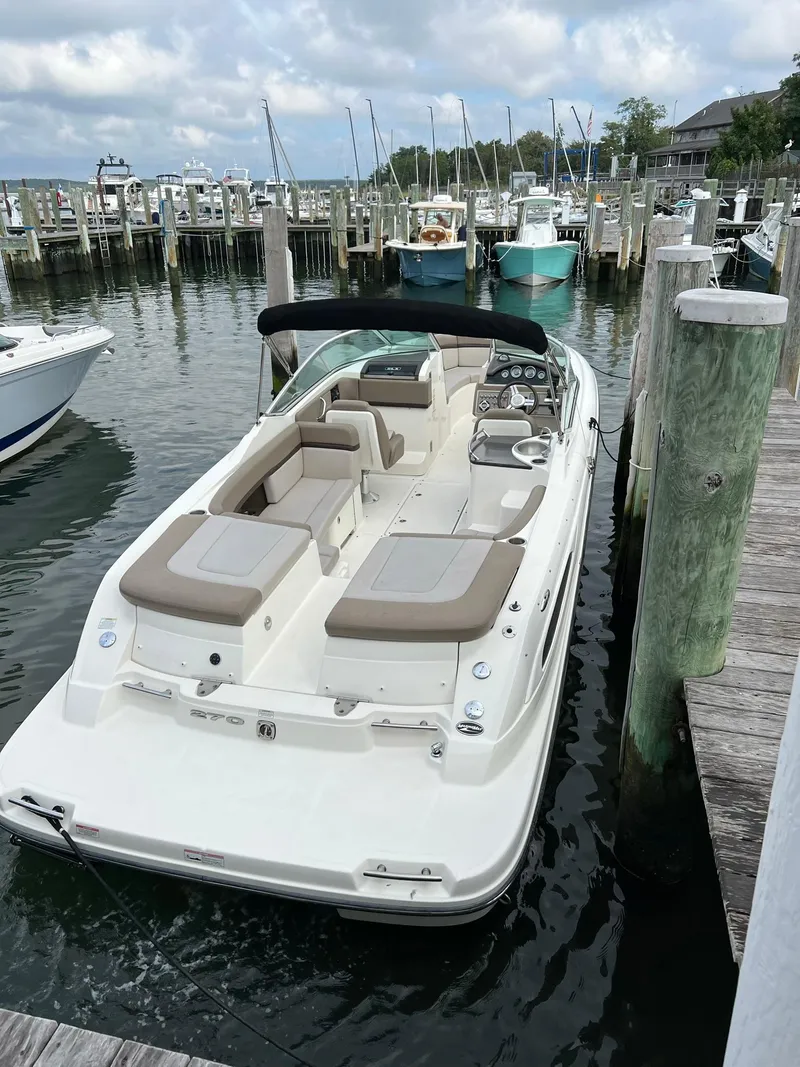 Slide: The Image of 2011 Sea Ray 270 SLX boat docked at a marina with calm waters. - 29