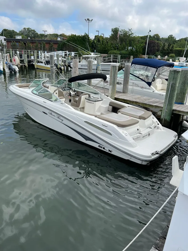 Slide: The Image of 2011 Sea Ray 270 SLX boat docked in a marina, featuring sleek design and spacious seating. - 30