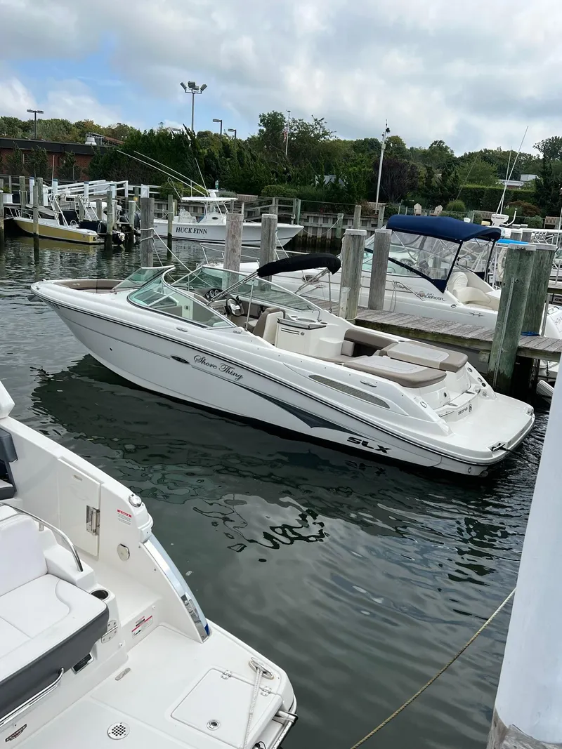 Slide: The Image of 2011 Sea Ray 270 SLX boat docked in a marina, surrounded by other vessels. - 31