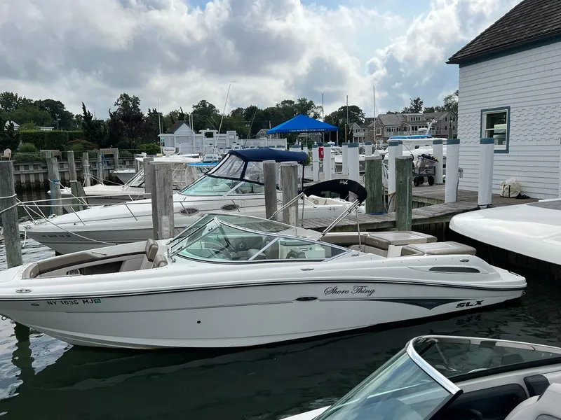 Slide: The Image of 2011 Sea Ray 270 SLX boat docked at a marina under cloudy skies. - 32