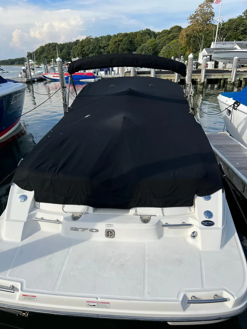 Slide: The Image of 2011 Sea Ray 270 SLX boat docked with black cover, surrounded by other boats. - 39