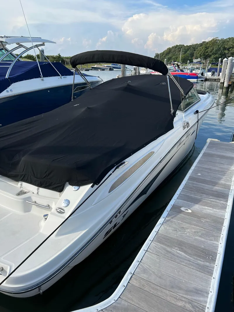 Slide: The Image of 2011 Sea Ray 270 SLX boat docked with black cover, marina background. - 40