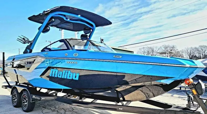 Slide: The Image of 2024 Malibu Wakesetter 23 MXZ boat in vibrant blue on a trailer. - 11
