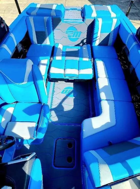 Slide: The Image of 2024 Malibu Wakesetter 23 MXZ interior with blue and white seating. - 15