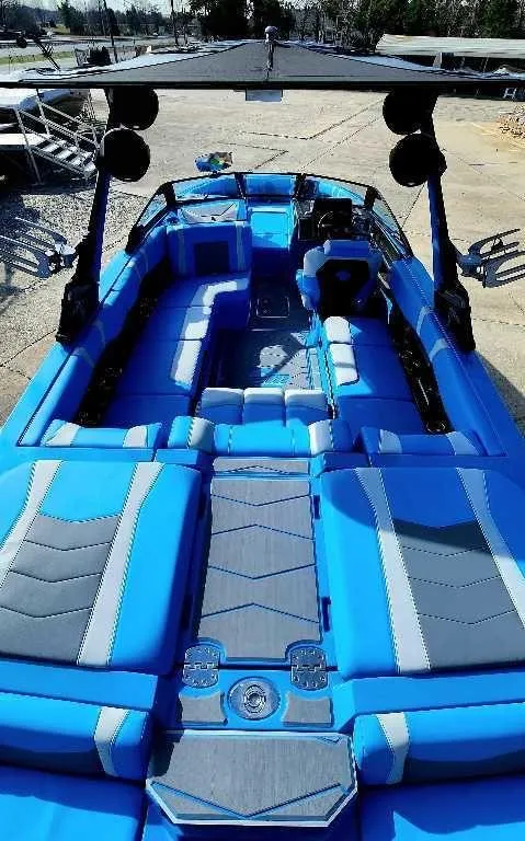Slide: The Image of 2024 Malibu Wakesetter 23 MXZ boat with blue and gray interior, spacious seating, and sleek design. - 16