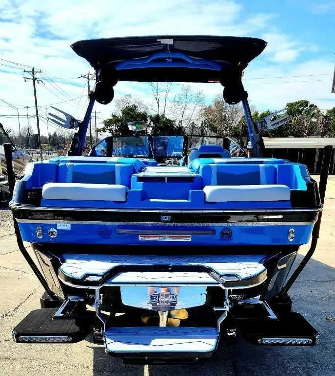 Slide: The Image of 2024 Malibu Wakesetter 23 MXZ boat, blue exterior, docked on a sunny day. - 5
