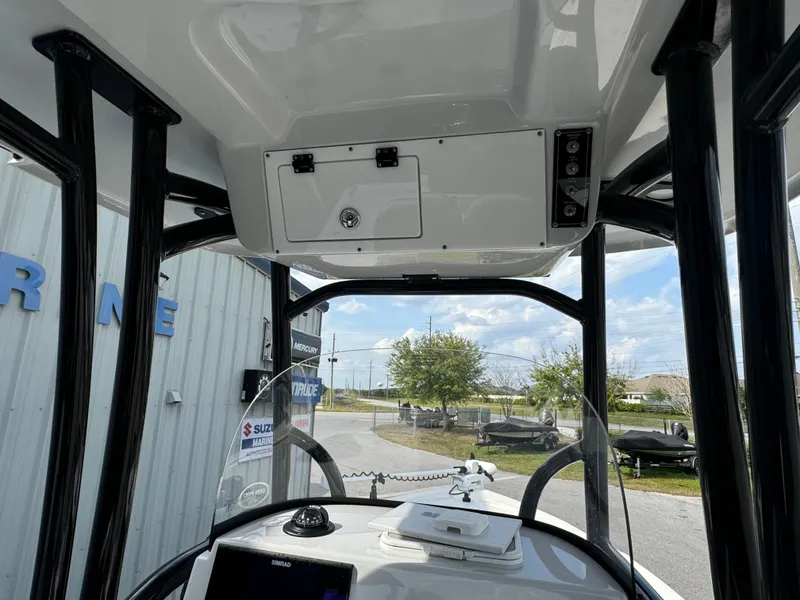 Slide: The Image of 2024 Sea Pro 248 boat console with overhead storage and clear sky view. - 19