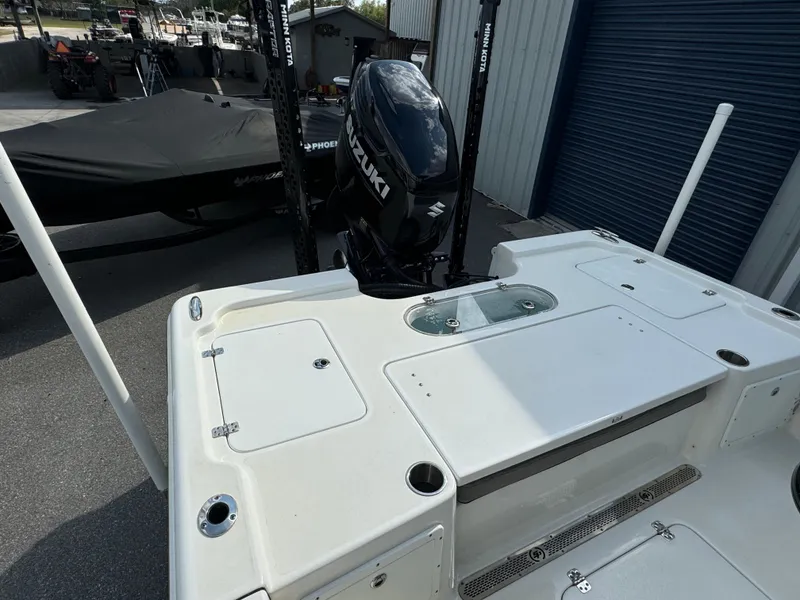 Slide: The Image of 2024 Sea Pro 248 boat with Suzuki outboard motor, docked near a blue garage door. - 22