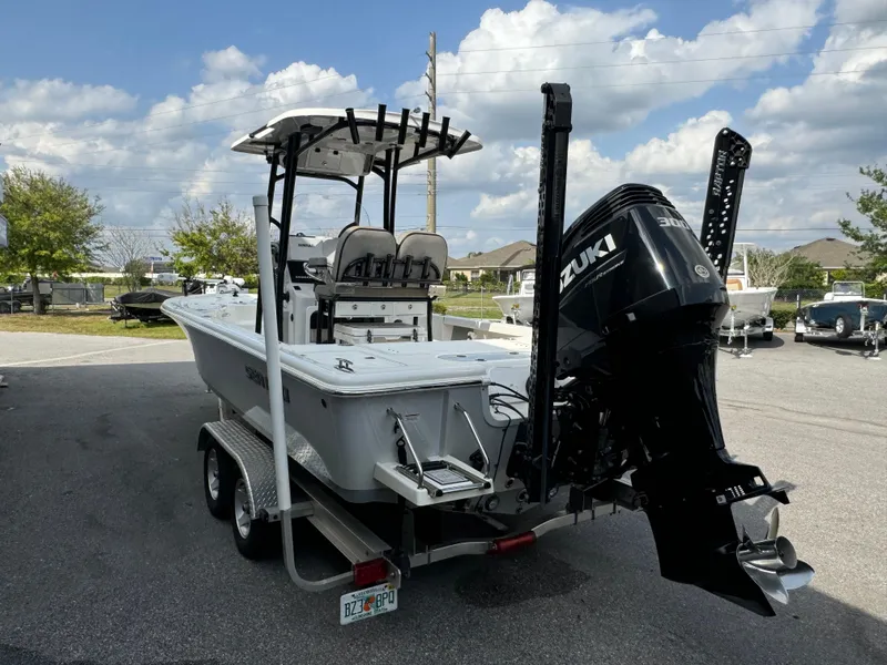 Slide: The Image of 2024 Sea Pro 248 boat with Suzuki outboard motor on a trailer, parked outdoors. - 25
