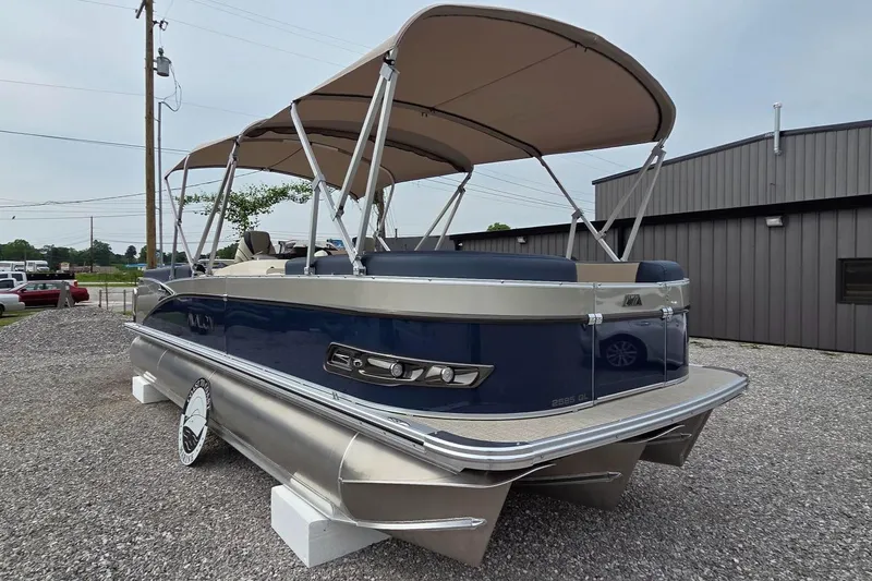 Slide: The Image of 2025 Avalon Platinum Catalina 2585 Quad Lounger pontoon boat with canopy, parked on gravel. - 12