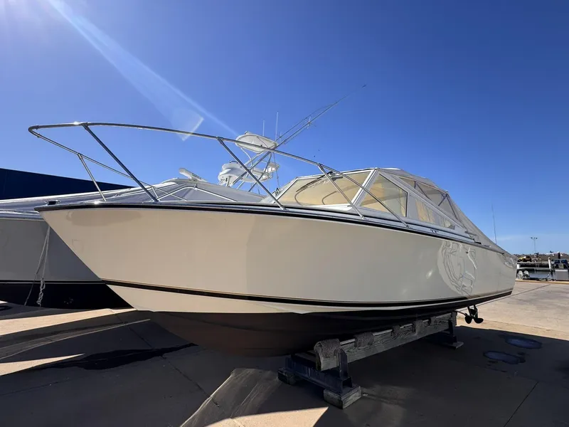 Slide: The Image of 1977 Bertram 28 Moppie boat on display under clear blue sky. - 0
