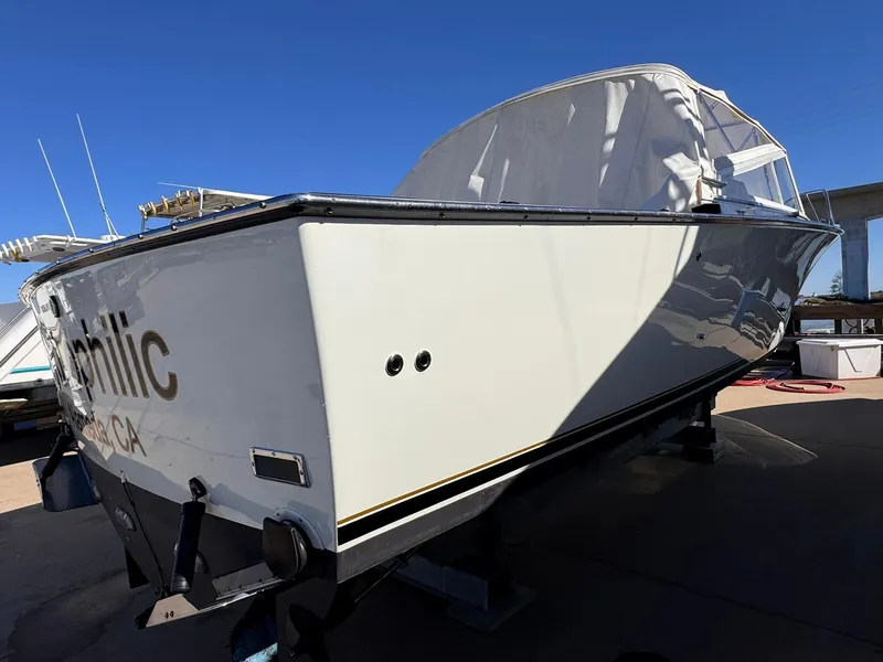 Slide: The Image of 1977 Bertram 28 Moppie boat on display under clear blue sky. - 10