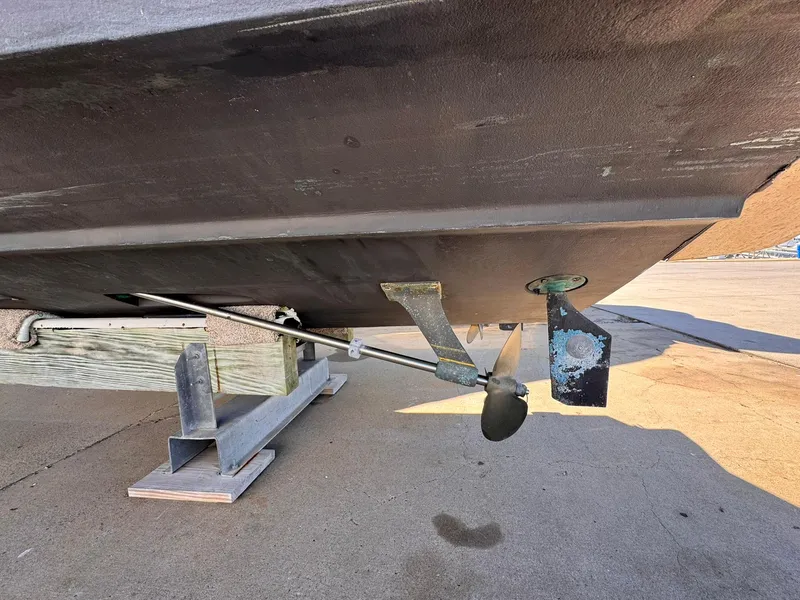 Slide: The Image of 1977 Bertram 28 Moppie boat underside showing propeller and rudder on a trailer. - 13