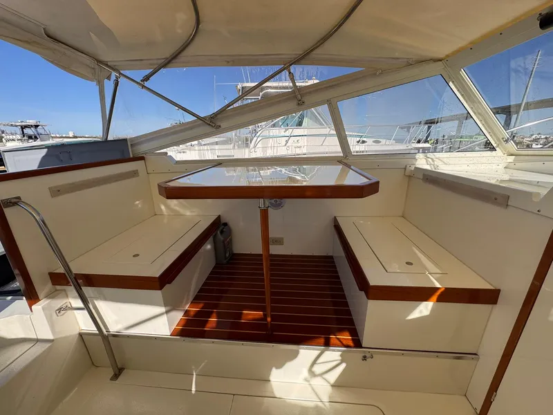Slide: The Image of 1977 Bertram 28 Moppie boat interior with seating and table, featuring wood accents. - 19