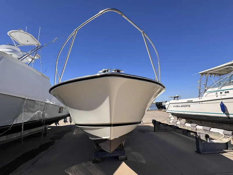 Slide: The Image of 1977 Bertram 28 Moppie boat on dry dock, front view under clear blue sky. - 2