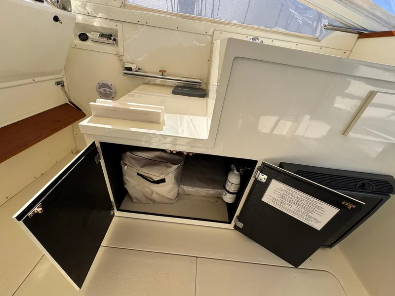 Slide: The Image of 1977 Bertram 28 Moppie interior with open storage compartments and countertop. - 21