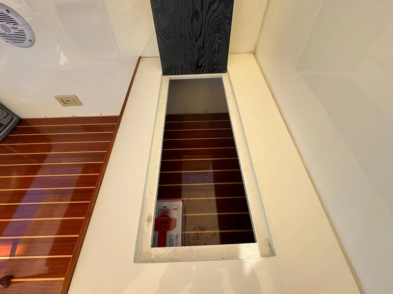 Slide: The Image of 1977 Bertram 28 Moppie interior with wooden flooring and storage compartment. - 22