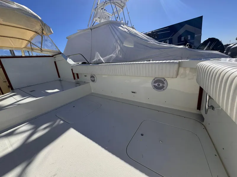 Slide: The Image of 1977 Bertram 28 Moppie boat deck with seating, under clear blue sky. - 29
