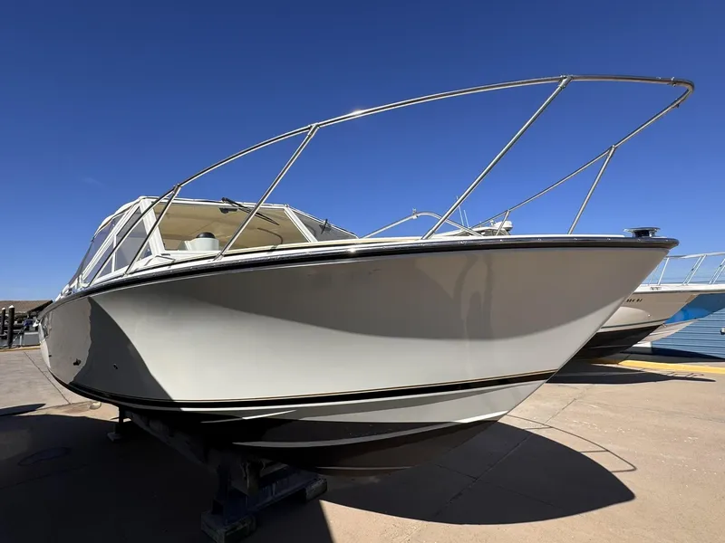 Slide: The Image of 1977 Bertram 28 Moppie boat with sleek design, docked under clear blue sky. - 3