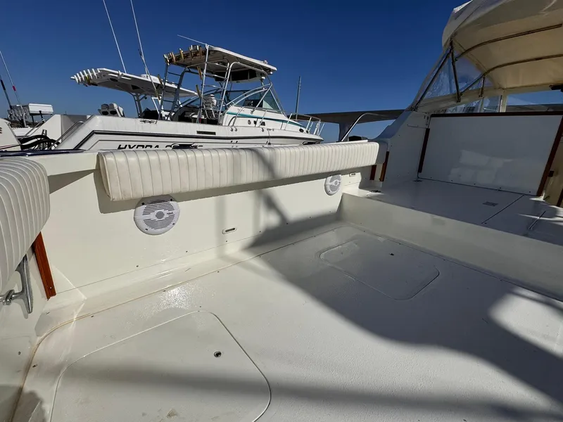 Slide: The Image of 1977 Bertram 28 Moppie boat deck with seating, under clear blue sky. - 30