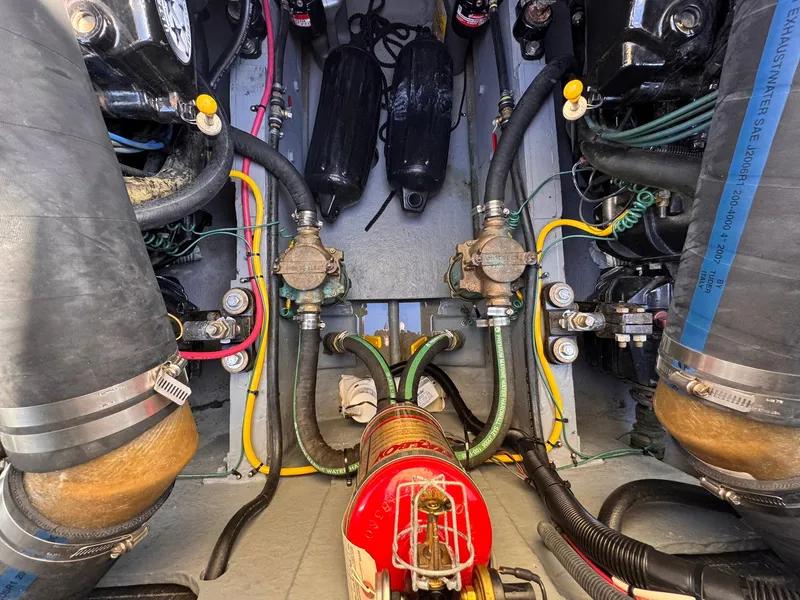 Slide: The Image of Engine compartment of a 1977 Bertram 28 Moppie boat, showcasing hoses and mechanical components. - 34