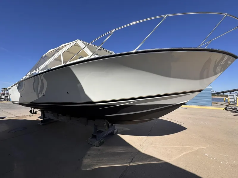 Slide: The Image of 1977 Bertram 28 Moppie boat on dry dock under clear blue sky. - 4