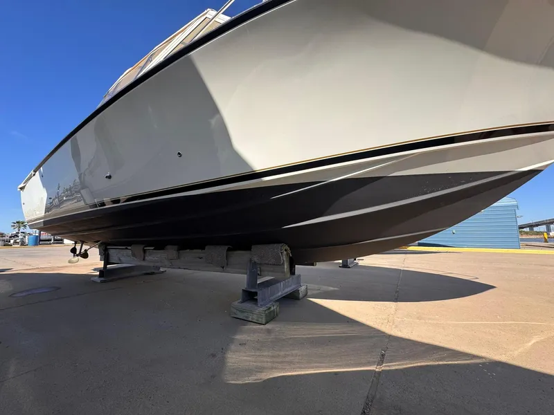 Slide: The Image of 1977 Bertram 28 Moppie boat on stands, viewed from below, in a sunny outdoor setting. - 6