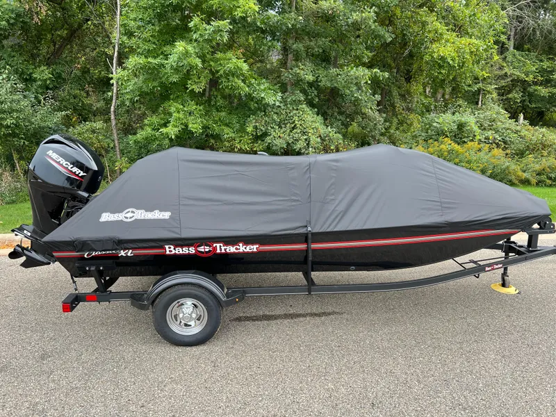 Slide: The Image of 2025 Tracker Bass Tracker Classic XL boat covered on trailer, parked outdoors. - 5