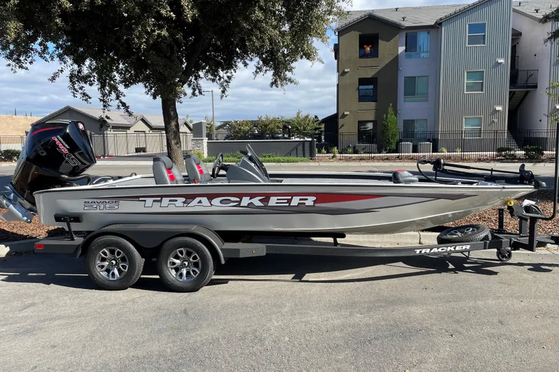 The Image of 2025 Tracker Savage 215 boat on trailer, parked outdoors near residential buildings. - 0