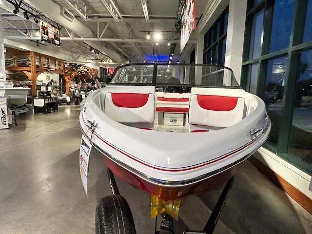Slide: The Image of 2025 Tahoe 200 S boat with red and white interior on display in showroom. - 1