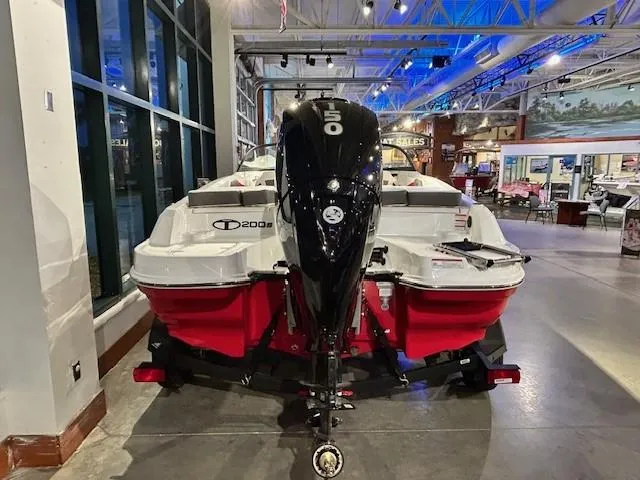 Slide: The Image of 2025 Tahoe 200 S boat with 150 HP engine displayed indoors. - 2